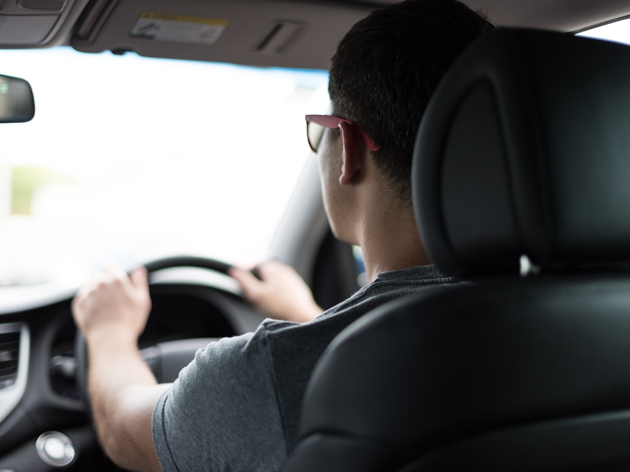 A learner driver and friendly instructor sitting in a dual-control car ready for a lesson